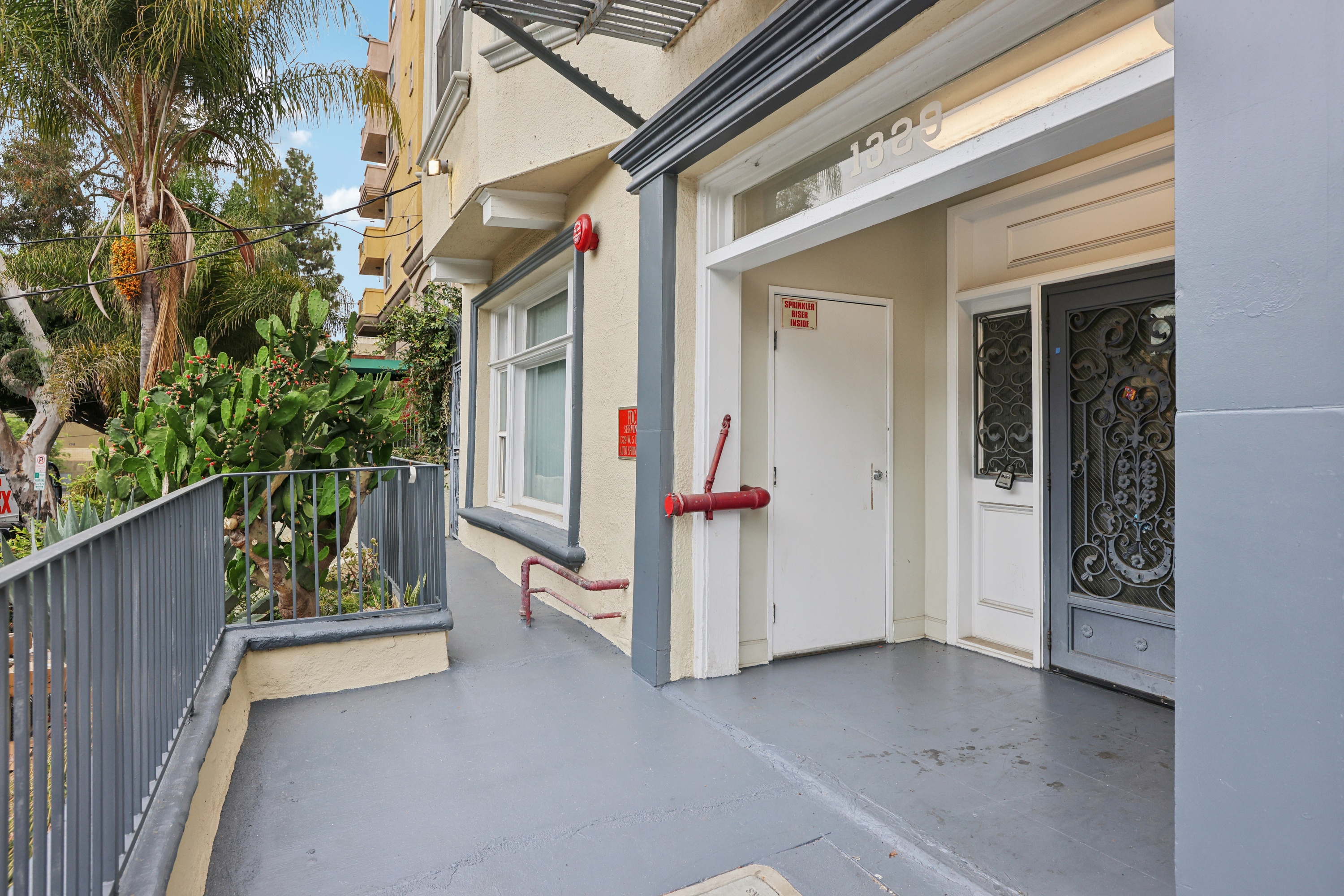 A balcony with a metal railing and a red rope tied to a post.